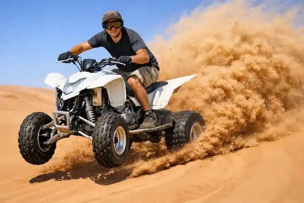cobra quad bike dust bashing in Dubai desert with rider performing off-road adventure